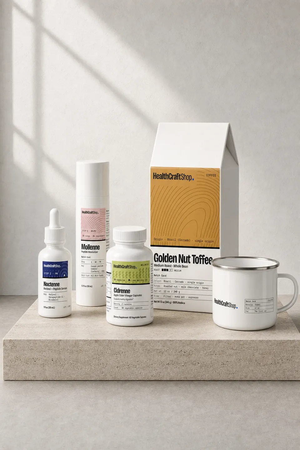 HealthCraftShop products on a travertine plinth in window light: Noctenne serum, Mollenne moisturizer, Cidrenne capsules, Golden Nut Toffee coffee and the enamel camp mug